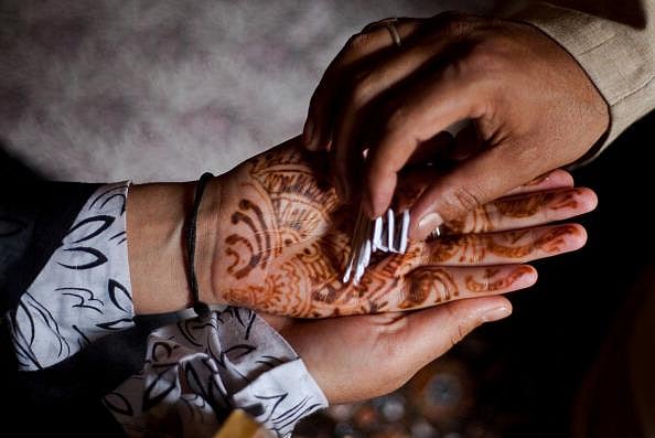 A Kashmiri Muslim woman receives relics from a 'pir or dervish'